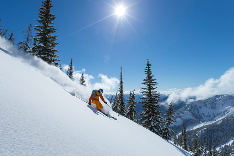 Male skier making turn on powder slope.